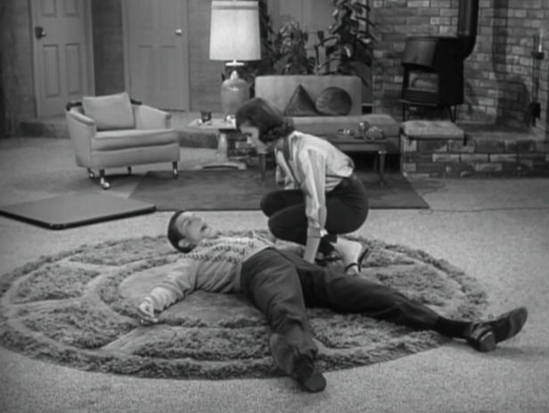 Laura finds Rob lying flat on the floor after he stumbles over one of Ritchie's toys. (Screen capture by Lindsey for TMP)