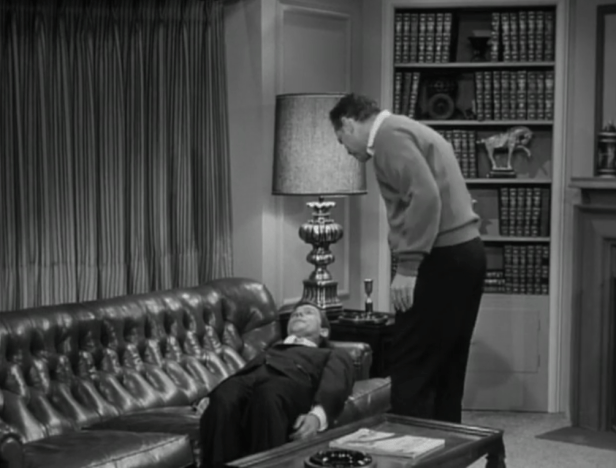 When Rob throws his back out, he can't even sit on the couch -- the doctor has to help him lay down! (Screen capture by Lindsey for TMP)