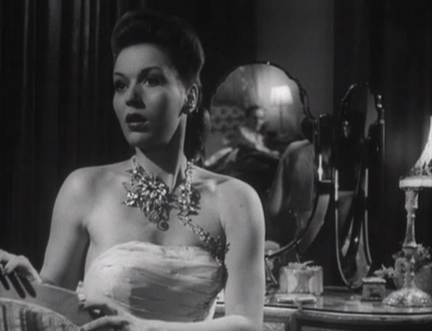 Lee (seen in the mirror) surprises Vivien by returning home a bit early from New York. (Screen capture by Lindsey for TMP)